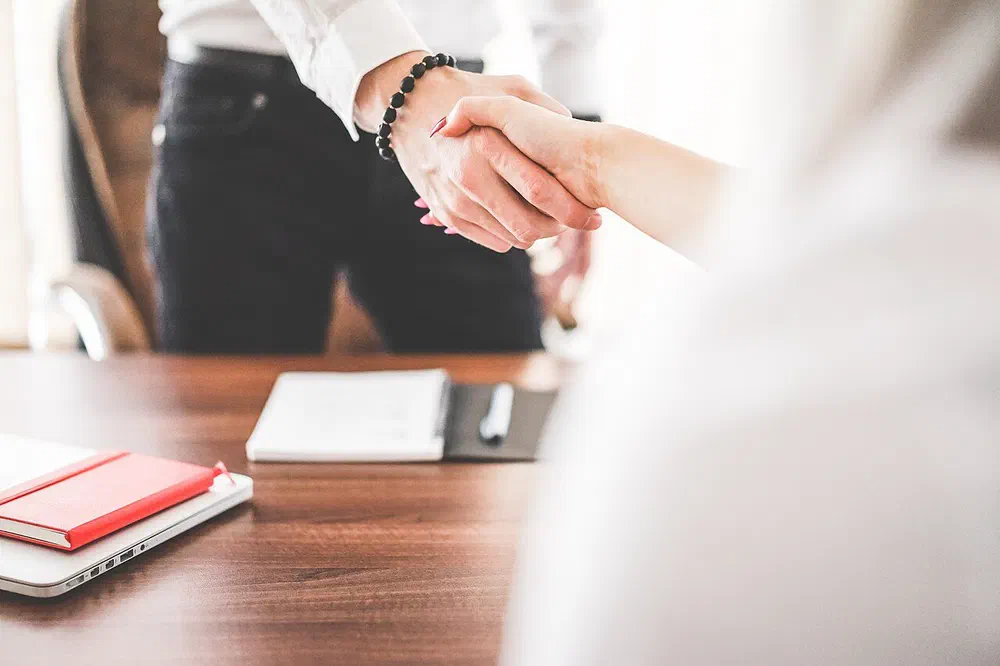 Colleagues shaking hands, aligned around the same customer information
